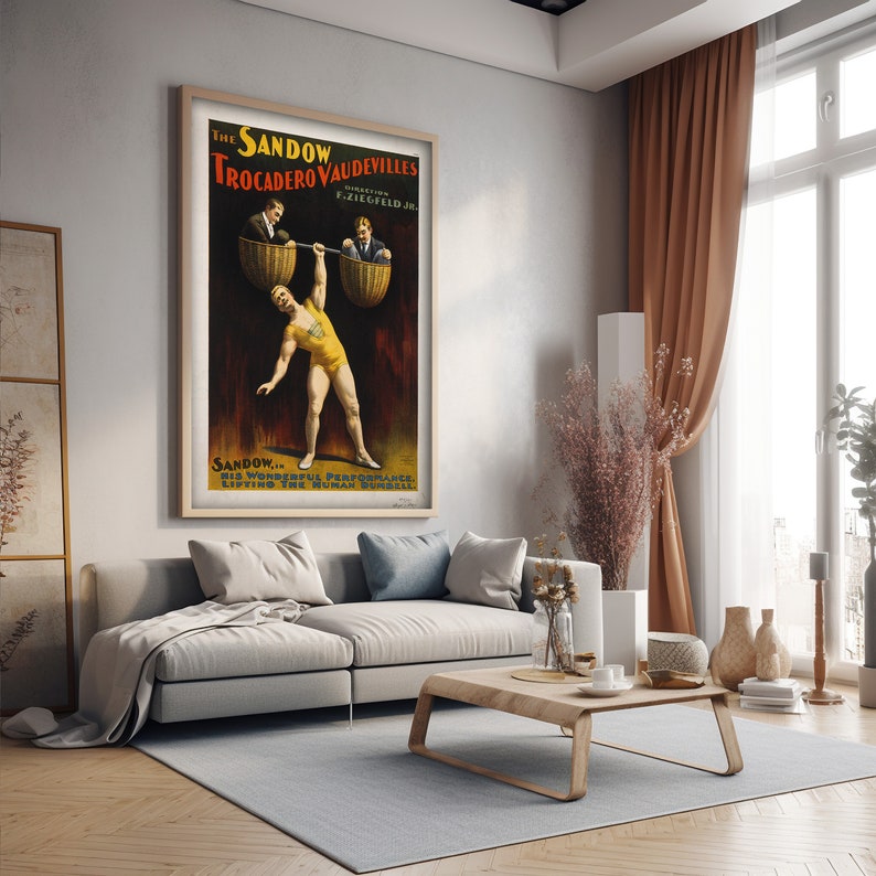 Puede incluir: P&oacute;ster vintage que anuncia "The Sandow Vaudevilles" en el Trocadero, con un hombre fuerte levantando a dos hombres en cestas. El p&oacute;ster est&aacute; en un marco de madera y colgado en una pared.