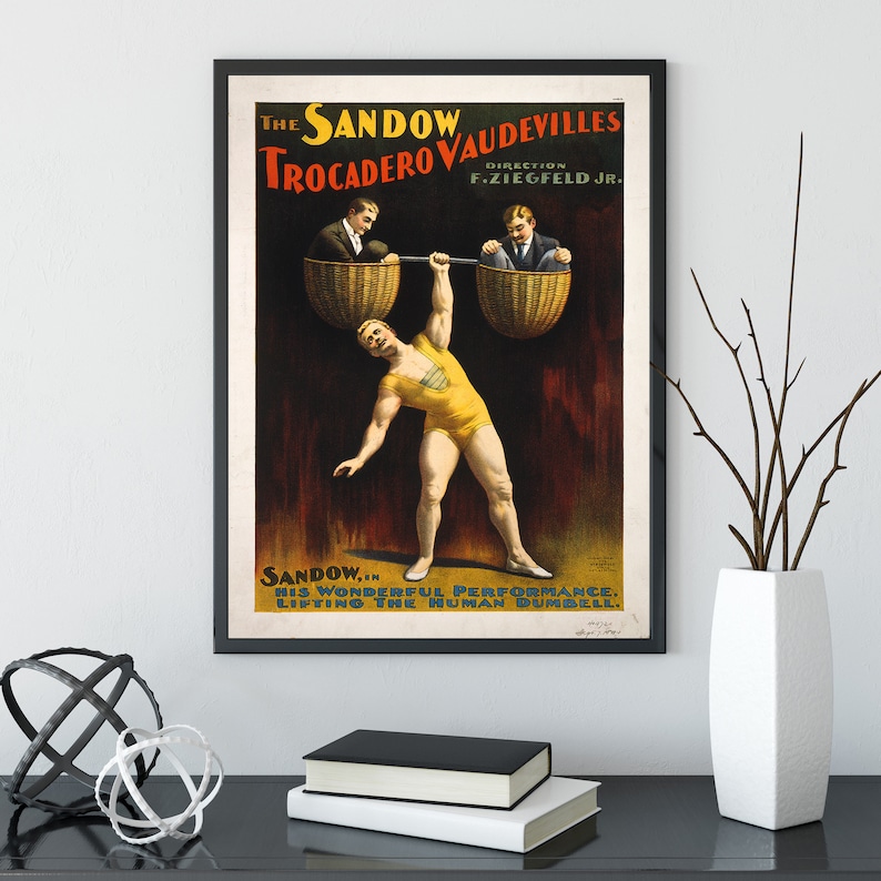 Puede incluir: Un cartel vintage que anuncia una actuaci&oacute;n de Sandow, un hombre fuerte, en los Trocadero Vaudevilles. El cartel muestra a un hombre levantando a dos hombres en cestas, con el texto "The Sandow Vaudevilles Trocadero Direction F. Ziegfeld Jr. Sandow... His Wonderful Performance. Lifting The Human Dumbbell."