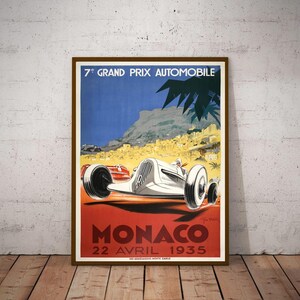 May include: Vintage poster advertising the 7th Grand Prix Automobile Monaco, held on April 22, 1935. The poster features a white race car speeding along a winding road with a backdrop of the city of Monaco and the Mediterranean Sea.