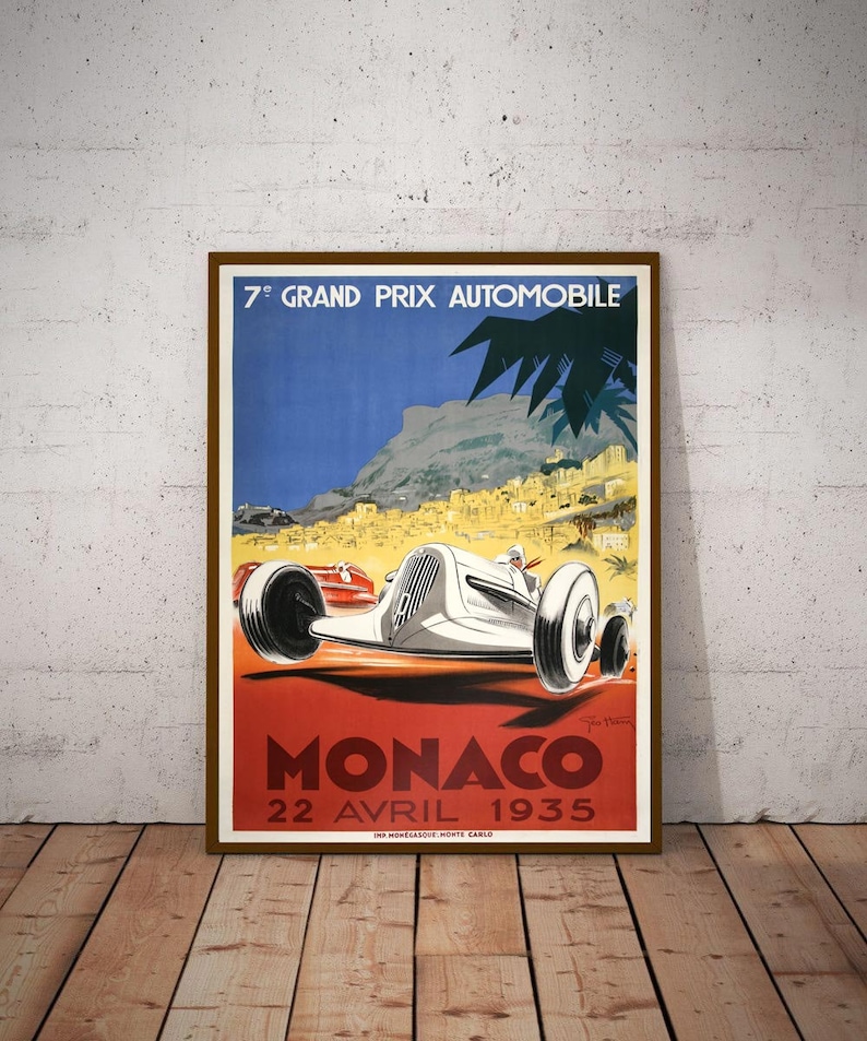 May include: Vintage poster advertising the 7th Grand Prix Automobile Monaco, held on April 22, 1935. The poster features a white race car speeding along a winding road with a backdrop of the city of Monaco and the Mediterranean Sea.
