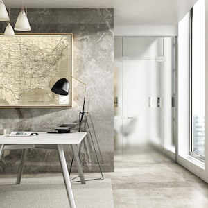 Puede incluir: Una silla de oficina blanca con reposacabezas y brazos ajustables, un escritorio blanco con una mesa blanca y patas de madera, una l&aacute;mpara negra con un soporte dorado y un mapa enmarcado de los Estados Unidos en una pared gris.