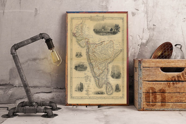 May include: A vintage map of South America in a wooden frame, with a rustic lamp and a wooden crate in the background.