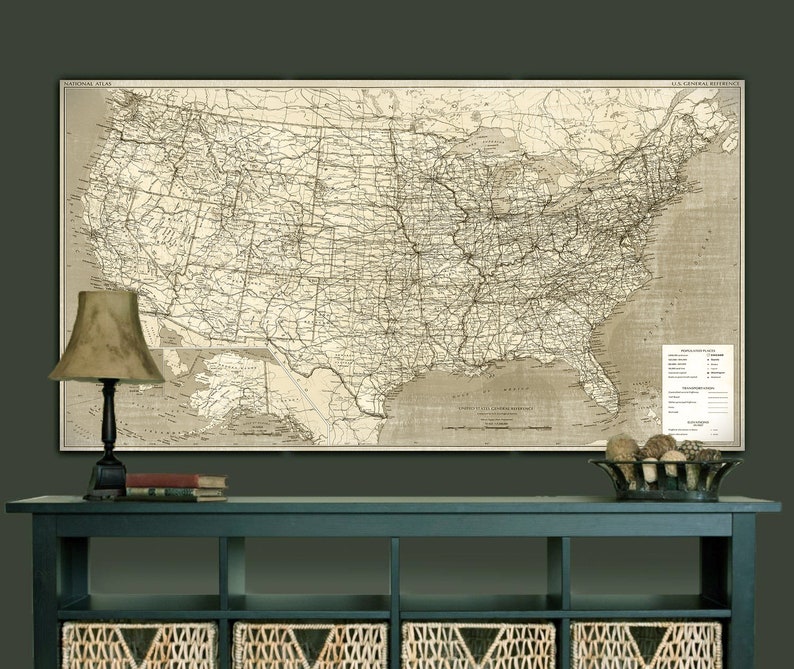 Puede incluir: Un mapa vintage de los Estados Unidos que muestra las l&iacute;neas de ferrocarril y las principales ciudades. El mapa est&aacute; impreso en papel de color crema y enmarcado en un marco negro sencillo. El mapa est&aacute; colgado en una pared verde oscuro sobre una consola azul oscuro con cestas de mimbre.