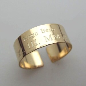 May include: Gold band ring with the inscription "Hugo Beau III. MMVI" engraved on the band.