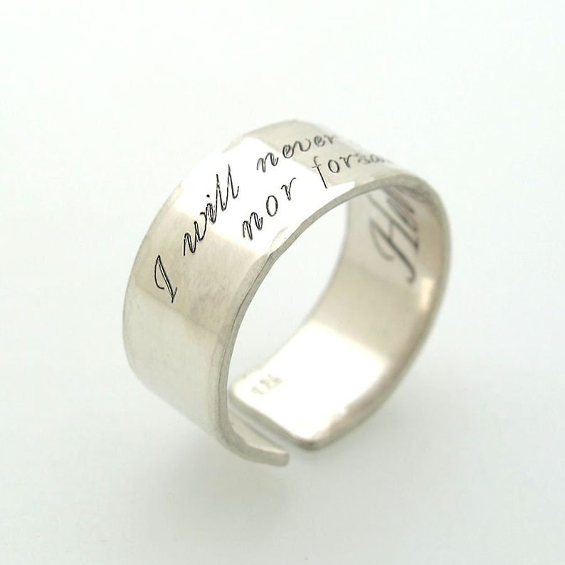 May include: A silver ring with the inscription "I will never nor forget" on the band.