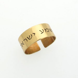 May include: Gold adjustable ring with Hebrew text engraved on the band. The text reads "Shema Yisrael" which translates to "Hear O Israel".