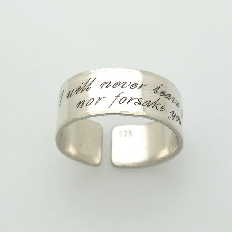 May include: Silver ring with the inscription "I will never leave nor forsake you".
