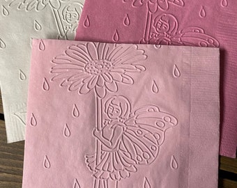 May include: Three pink paper napkins with an embossed design of a fairy holding a daisy with raindrops falling around her.