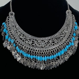 Vintage Tribal Halskette. Antikes silberfarbenes Metall mit großem filigranen Frontstück, jede Schlaufe hat eine blaue Perle und Blattmotiv. Haken Cl