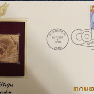 May include: A gold-plated commemorative stamp featuring Flash Gordon, a comic strip character, with the text "Flash Gordon" and "Comics Classic Collection" printed on the envelope. The stamp is dated October 1, 1995, and the envelope is postmarked Boca Raton, FL.