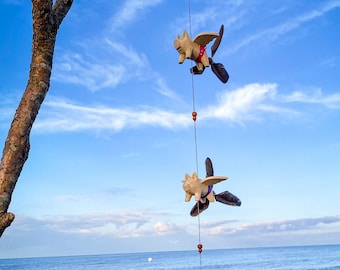 3 Schweinchen Windspiel mit bunten Badehosen und Propeller.