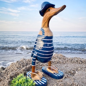 Anatra corridore con cappello e infradito in costume da bagno a righe blu scuro e bianche, alta 28 cm