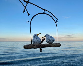 Seagulls on driftwood with propeller in metal bracket.