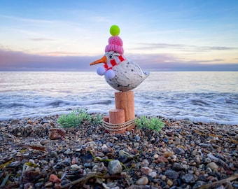 Seagull in antique white on bollard with poodle cap and scarf about 20 cm high.
