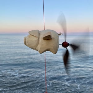 3 pig wind chime made of wood in natural with propeller.