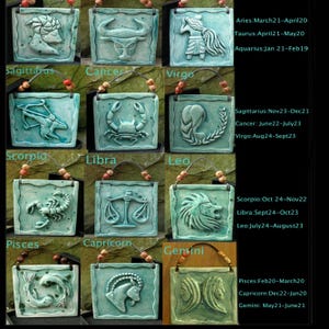 May include: Twelve ceramic tiles, each depicting a different zodiac sign with its corresponding name and dates. The tiles are painted in shades of blue and green, with a textured surface. The tiles are arranged in a grid pattern, with the names of the signs written below each tile.
