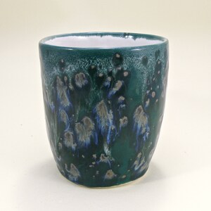 May include: A green ceramic mug with a white interior and a blue and white marbled design.