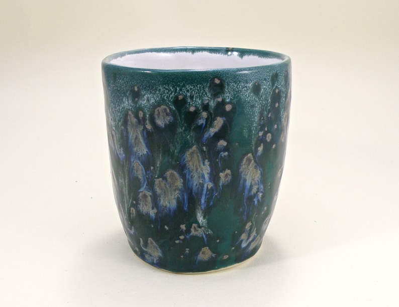 May include: A green ceramic mug with a white interior and a blue and white marbled design.