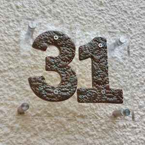 May include: A clear acrylic house number sign with the number 31 in brown with a textured, metallic finish.