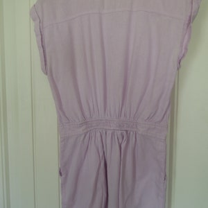May include: A light purple short-sleeved jumpsuit with a button-up front and a gathered waist.