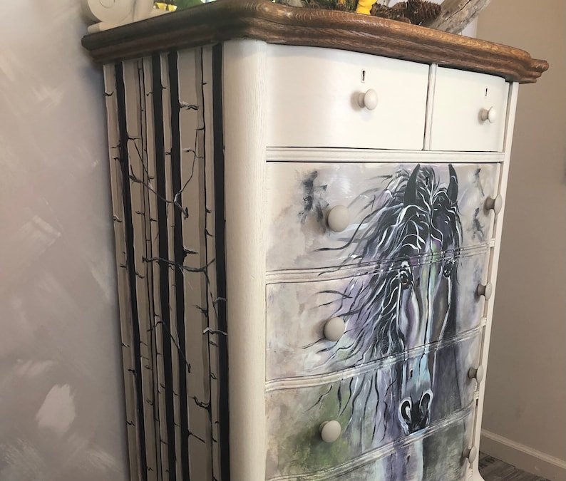 Puede incluir: C&oacute;moda blanca pintada con cinco cajones. Los cajones est&aacute;n decorados con una ilustraci&oacute;n de un caballo en blanco y negro. El lateral de la c&oacute;moda est&aacute; pintado con un dise&ntilde;o de &aacute;rbol de abedul en blanco y negro.