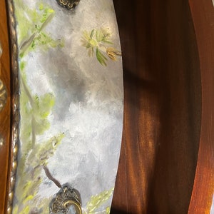 Pode incluir: Close-up de uma gaveta de madeira com um design floral pintado. A gaveta tem duas puxadores de lat&atilde;o ornamentados. A gaveta est&aacute; aberta e o interior &eacute; vis&iacute;vel.