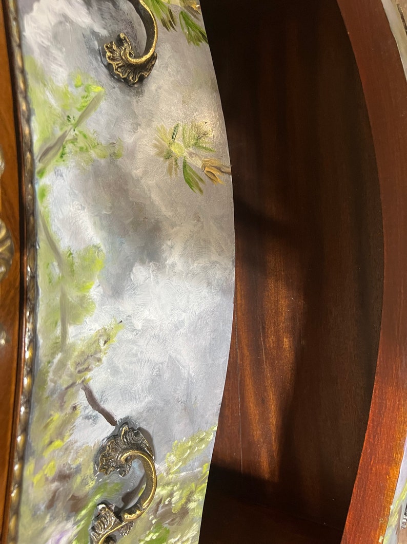 Pode incluir: Close-up de uma gaveta de madeira com um design floral pintado. A gaveta tem duas puxadores de lat&atilde;o ornamentados. A gaveta est&aacute; aberta e o interior &eacute; vis&iacute;vel.