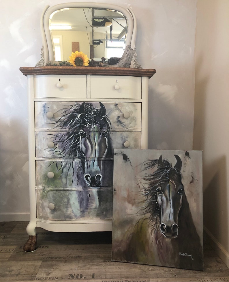 Puede incluir: Una c&oacute;moda antigua pintada de blanco con un espejo en la parte superior. La c&oacute;moda tiene seis cajones con una pintura de caballo en blanco y negro en la parte delantera de los cuatro cajones superiores. Una pintura separada de caballo en blanco y negro se apoya contra la c&oacute;moda. La pintura est&aacute; firmada "Ruth Stacey".