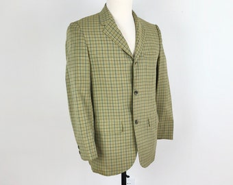 May include: A tan blazer with a black and yellow plaid pattern. The blazer has a three-button closure and a single flap pocket on the left side.