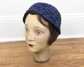 May include: A blue sequined hat with a rounded shape. The hat is made of a soft, sparkly fabric and has a simple design.