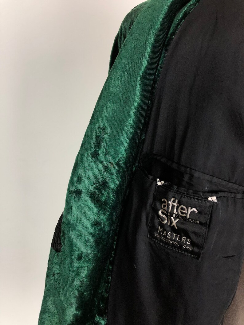 May include: A dark green velvet jacket with a black lining. The jacket has a pocket on the left side with a black and white label that reads "after six by rudofker masters youngstown, ohio".