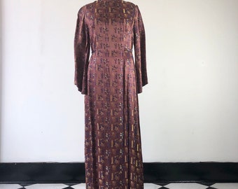 May include: A long, brown silk dress with a geometric pattern of gold and purple figures. The dress has a high neck and long sleeves.