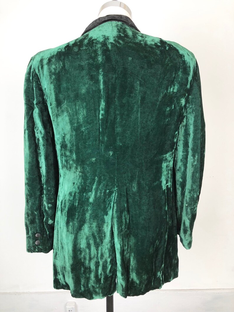 May include: A dark green velvet blazer with a black collar. The blazer has a classic cut and is made of a soft, luxurious fabric.