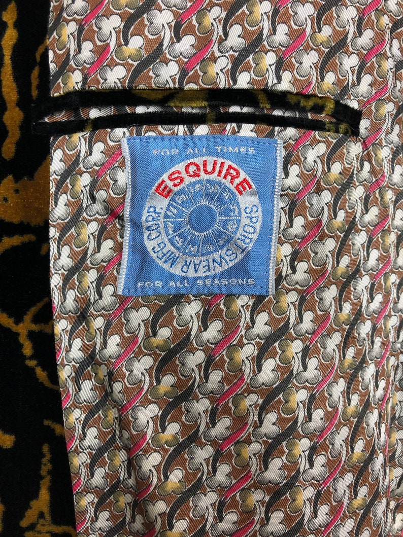 May include: A blue and white label with the text "Esquire Sportswear for all times for all seasons" and a circular design with a sun and the words "All Weather" and "Sportswear" around it.