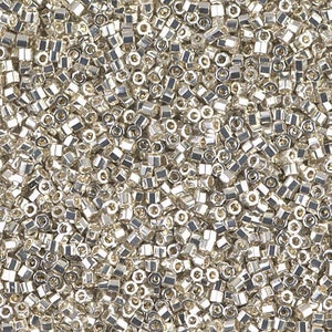 May include: A close-up view of a large quantity of silver-colored seed beads. The beads are small and round, with a slightly irregular shape. They are perfect for jewelry making or other craft projects.