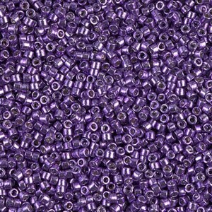 May include: A close-up view of a large quantity of small, round, metallic purple beads. The beads have a shiny, iridescent finish.