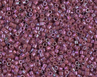 May include: A close-up view of a large quantity of small, round, iridescent purple beads. The beads have a metallic sheen and are perfect for jewelry making or crafting.