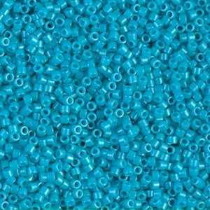 May include: A close-up shot of a pile of turquoise-colored seed beads. These small, cylindrical beads are uniform in size and shape, with a hole running through the center. They are ideal for jewelry making and crafting projects.