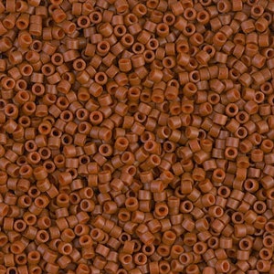 May include: A close-up image of a large quantity of small, brown, round beads. The beads are all the same size and shape, and they are arranged in a random pattern.
