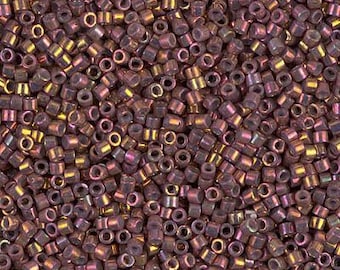 May include: A close-up view of a large quantity of small, round, iridescent purple beads. The beads have a metallic sheen and are perfect for jewelry making.