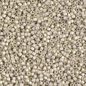 May include: A close-up view of a pile of small, cylindrical beads. The beads are a pale, off-white color and have a hole running through the center. They are densely packed together, creating a textured surface. These beads are suitable for jewelry making and crafts.