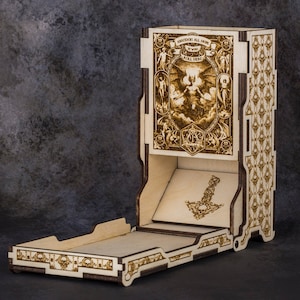 May include: A wooden dice tower with intricate laser-cut designs. The tower features a detailed illustration with the text "AMATEURS ALL AROUND, ROLL HERE". The design includes a dice tray and a hammer symbol. The overall theme is related to tabletop gaming.