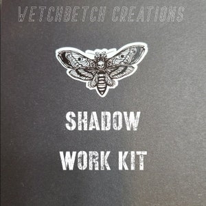 May include: Black square with a moth sticker and the words "WETCHBETCH CREATIONS", "SHADOW", and "WORK KIT" in white. The moth has a skull on its head and detailed wing patterns.