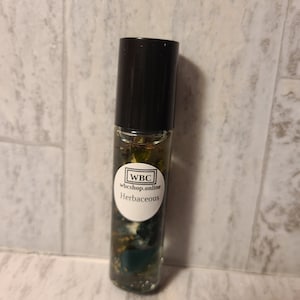 May include: A small glass bottle with a black cap filled with a green liquid and botanicals. The label reads "WBC wbcshop.online Herbaceous."