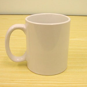 K&ouml;nnte beinhalten: Ein schlichter wei&szlig;er Keramikbecher mit glatter, gl&auml;nzender Oberfl&auml;che und einem geschwungenen Henkel auf der linken Seite. Der Becher hat einen zylindrischen K&ouml;rper mit einer weiten, offenen Oberseite und einem festen Boden f&uuml;r Getr&auml;nke.
