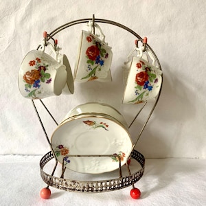 Flowered porcelain coffee service, metal cup and saucer holder