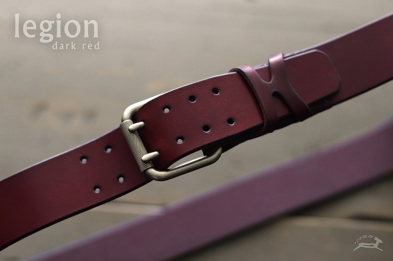 May include: A dark red leather belt with a brass buckle. The belt has a "legion dark red" label.