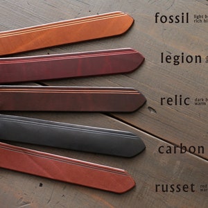 May include: Five leather straps in different colors and textures, labeled with names and descriptions. The colors are: fossil (light brown), legion (deep red), relic (dark brown), carbon (deep black), and russet (red brown).