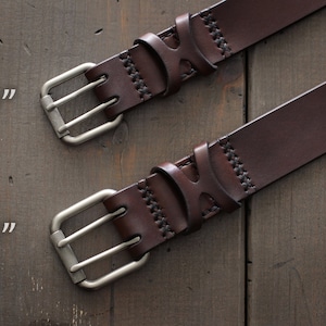 May include: Two brown leather belts with silver double prong buckles. The belt on the top has a 1.25 inch width and the belt on the bottom has a 1.5 inch width.
