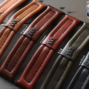 May include: Close-up of six leather watch straps in different colors and textures, including natural, fossil, legacy, russet, bog, and carbon. Each strap has a contrasting thread color and a stitched design. The text "thread option" is displayed above a color chart with the thread colors: white, grey, tan, brown, blue, red, yellow, and black.